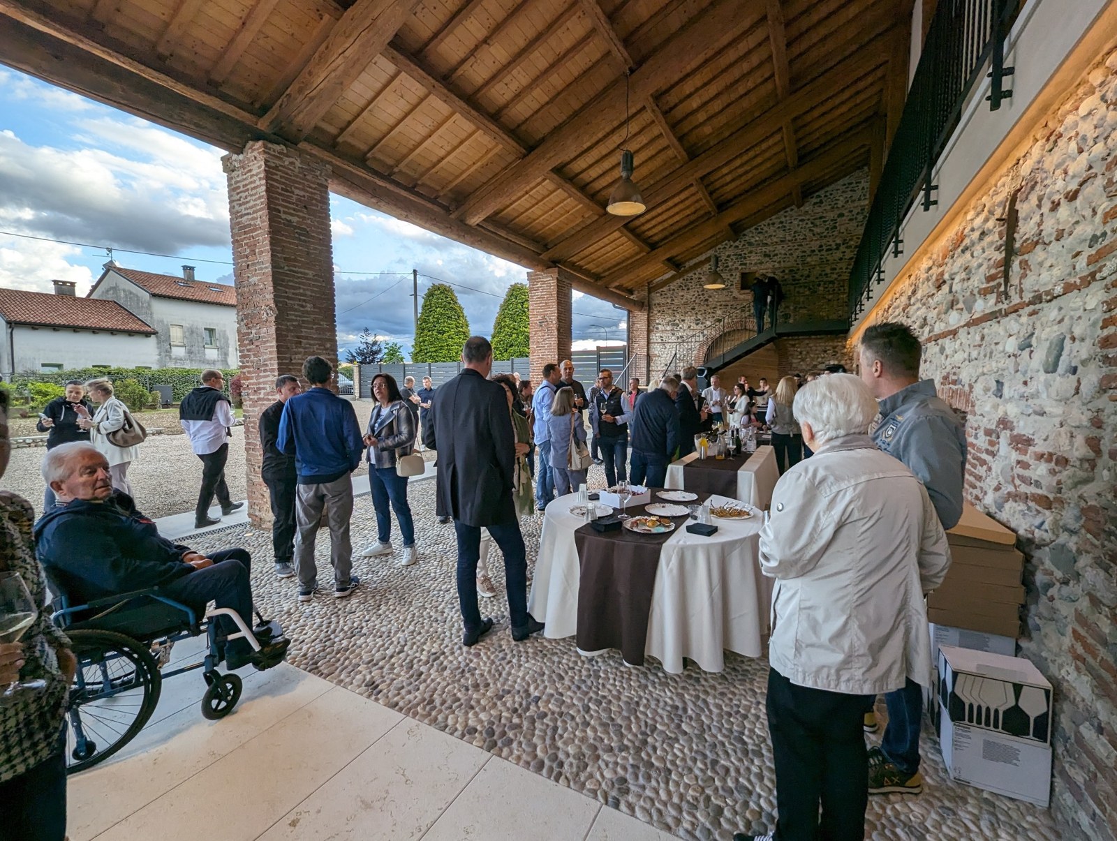 Un evento sotto il portico in pietra di Cà Breganze, con ospiti e tavoli allestiti